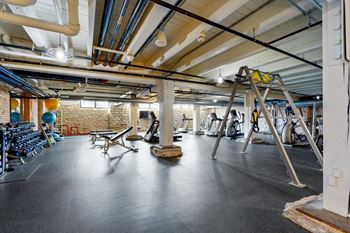 A gym with a variety of exercise equipment is shown.